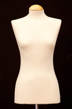 Bare-breasted mannequin isolated on black background