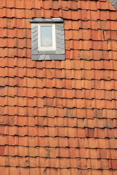 Skylight in an old building covered with red roof tiles