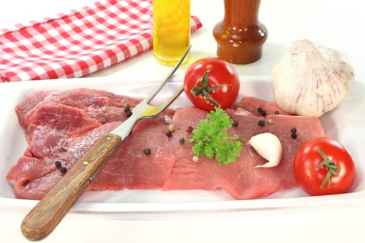 two raw pork steaks on a white serving platter