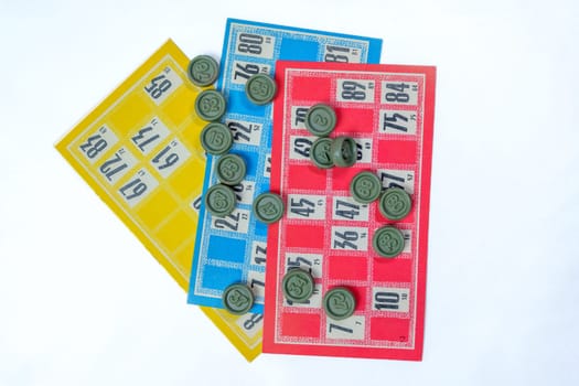 Three colorful vintage bingo cards with numbered green tokens on a white background. Classic lottery board game concept. Ideal for gambling, luck, and entertainment themes