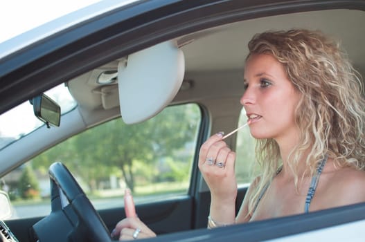 Young woman doing make up in car