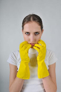 Young woman wearing yellow work gloves with thoughtful expression
