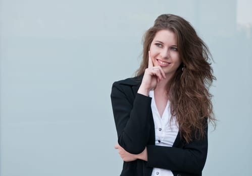 Young smiling business woman - portrait against plain glass background