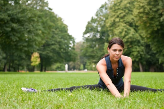 Woman performs stretching before sport in park