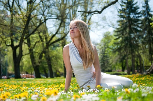 Smiling happy young terson (teen girl) sitting outdoors looking away