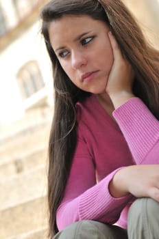Portrait of young worried woman (teenage girl) in depression outdoors