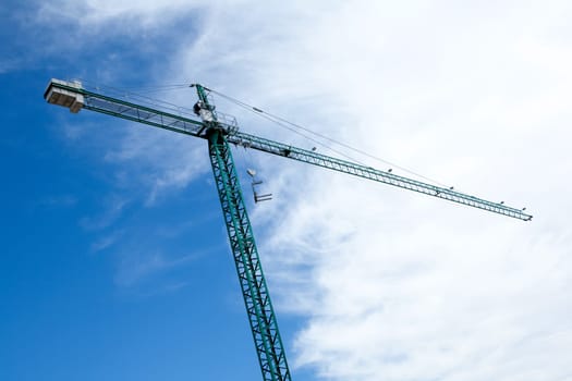 Huge construction crane with cloudy sky background