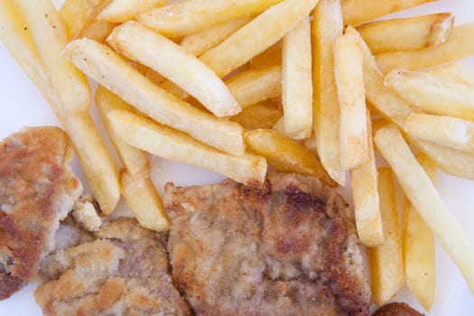 Chips and cooked pork fillets. Example of fast food