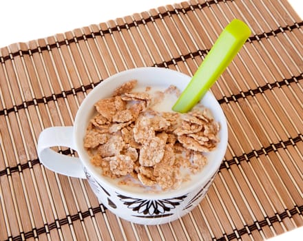 Breakfast bowl of cereal and milk on bamboo tablecloth