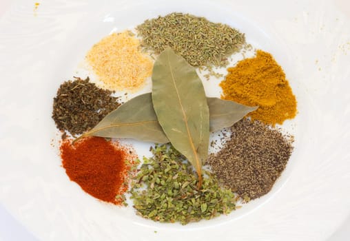 White dish with many spices of different colours