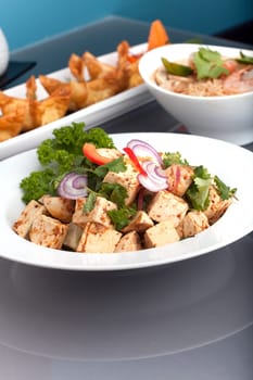 A nice assortment of Thai food and appetizers presented beautifully with fancy garnish with copy space.
