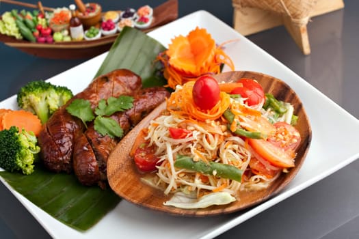 A dish of freshly prepared Thai sausage and som tum green papaya salad.