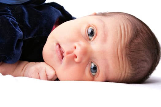 A cute newborn baby girl laying on a white backdrop.
