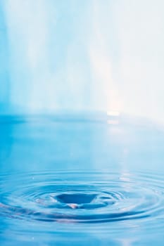 Close up of some clear blue water with circular ripples and plenty of copyspace.