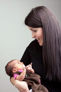 A newborn baby being held in the arms of her mother.