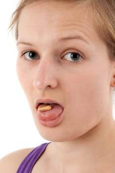 Young woman swallowing capsule