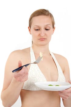 Young woman in bikini eating noodles from a small plate
