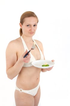 Young woman in bikini eating noodles from a small plate