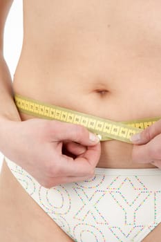 Young woman measuring her abdominal circumference