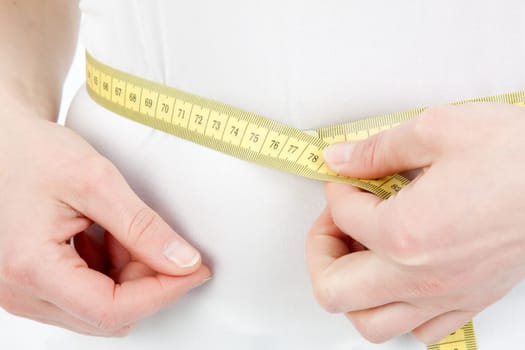 Young woman measuring her abdominal circumference