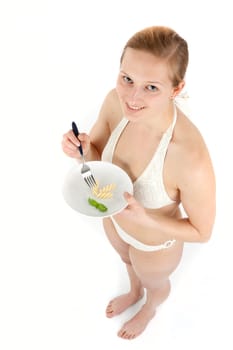 Young woman in bikini eating noodles from a small plate