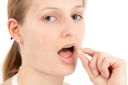 Young woman taking capsule
