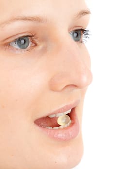 Young woman with a pill between her teeth