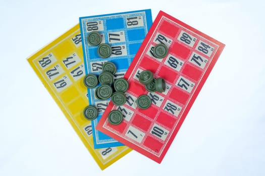 Three colorful vintage bingo cards with numbered green tokens on a white background. Classic lottery board game concept. Ideal for gambling, luck, and entertainment themes