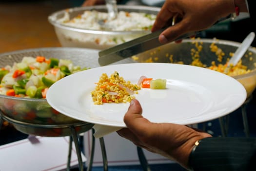 A person helping himself with some indian food