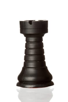 Black rook chess piece isolated on white background with reflection on the floor