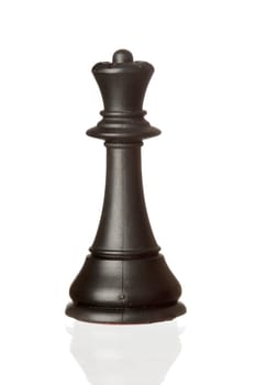 Black queen chess piece isolated on white background with reflection on the floor