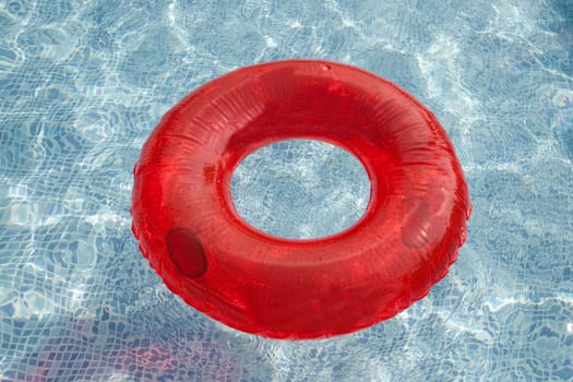 Red float floating in the pool with blue water