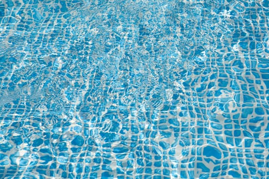 Wall of swimming pool with water of blue color