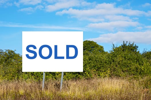 Blank billboard with message "sold"" in the field"