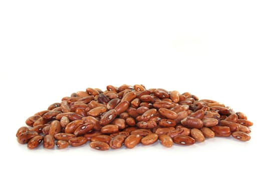 a handful of dried quail beans against a white background