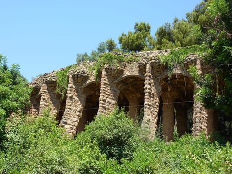 Columns, arches and vegetation at park Guell, Barcelona, Spain. This park was ordered by count Eusebio Guell to architect Antoni Gaudi who built it between 1900 and 1914. In 1984, Unesco declared this park world heritage.