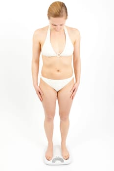 Young woman swaying on a bathroom scale