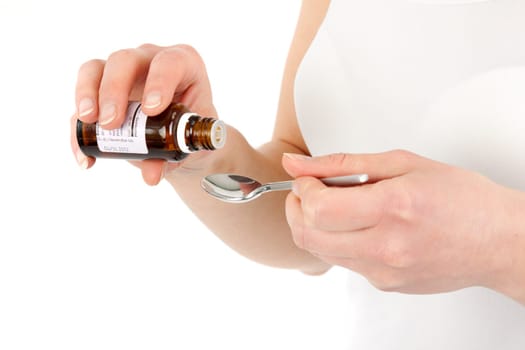 Young woman dripping medicine into a spoon