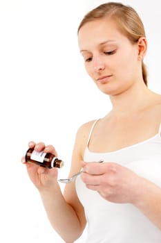 Young woman dripping medicine into a spoon