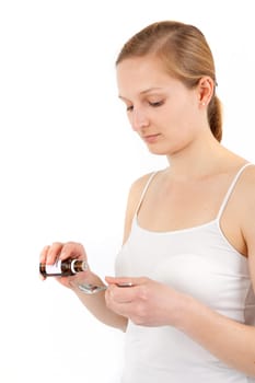 Young woman dripping medicine into a spoon