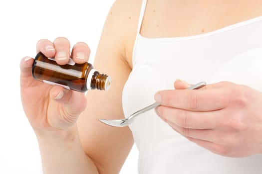 Young woman dripping medicine into a spoon