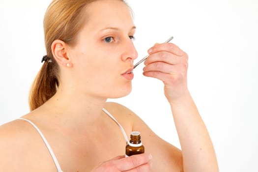 Woman taking medical drops