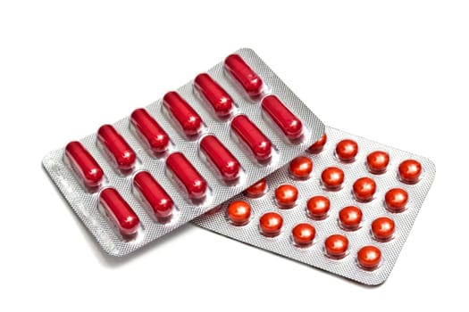 Red pills and capsules isolated on white background