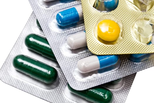 Different capsules and pills closeup on white background