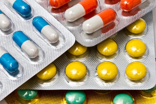 Background of colorful capsules and pills closeup