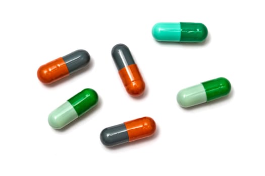 A few colorful capsules isolated on white background
