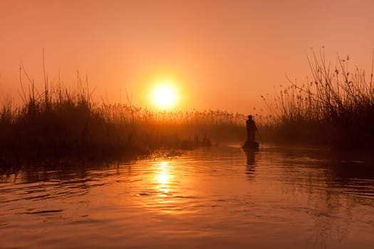 a fishing boat on the lake at sunrise