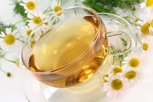 a cup of chamomile tea with fresh flowers