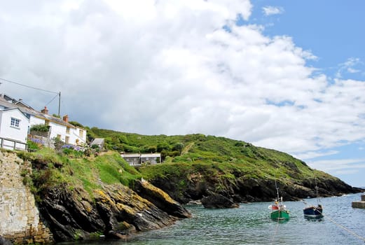 The Peaceful Cornish Harbour of Portloe with Fishing Boats under a blue sky