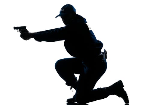Side view of a silhouetted Afro American police officer aiming gun isolated on white background